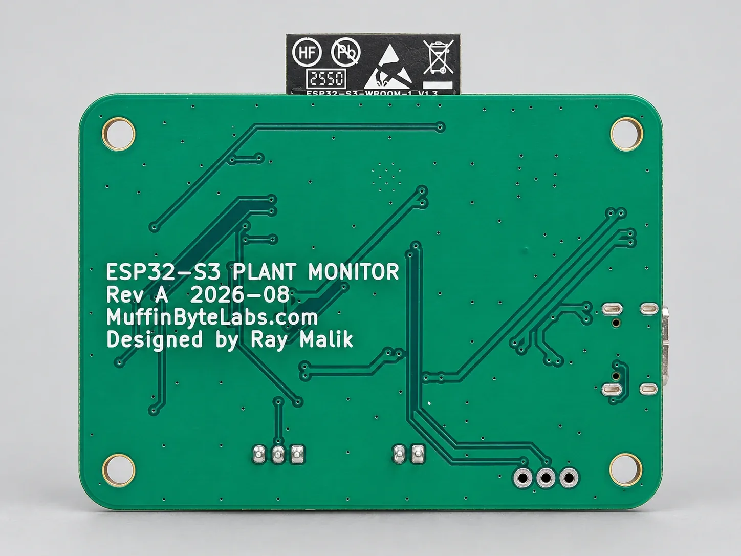 The back of the assembled board: routing over the ground planes, the through-hole UART pads, and a silkscreen block reading ESP32-S3 Plant Monitor, Rev A 2026-08, MuffinByteLabs.com, Designed by Ray Malik